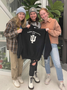 Students holding up a Cyber Security Club Sweatshirt