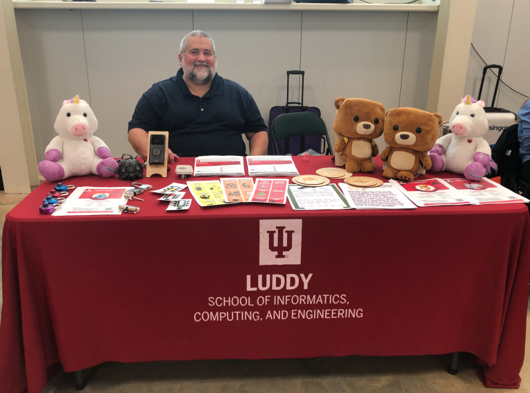 Joshua Streiff sitting at a table for the Luddy School of Informatics, Computing, and Engineering for the IVY Tech STEM and Life Sciences Career Fair