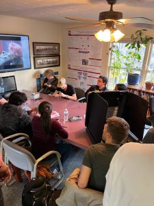 Group of students sitting in chairs trying to pick locks watching a video