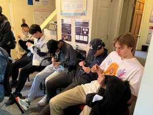 Group of students sitting in chairs trying to pick locks