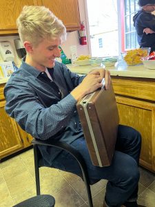 student sitting in a chair lock picking a briefcase